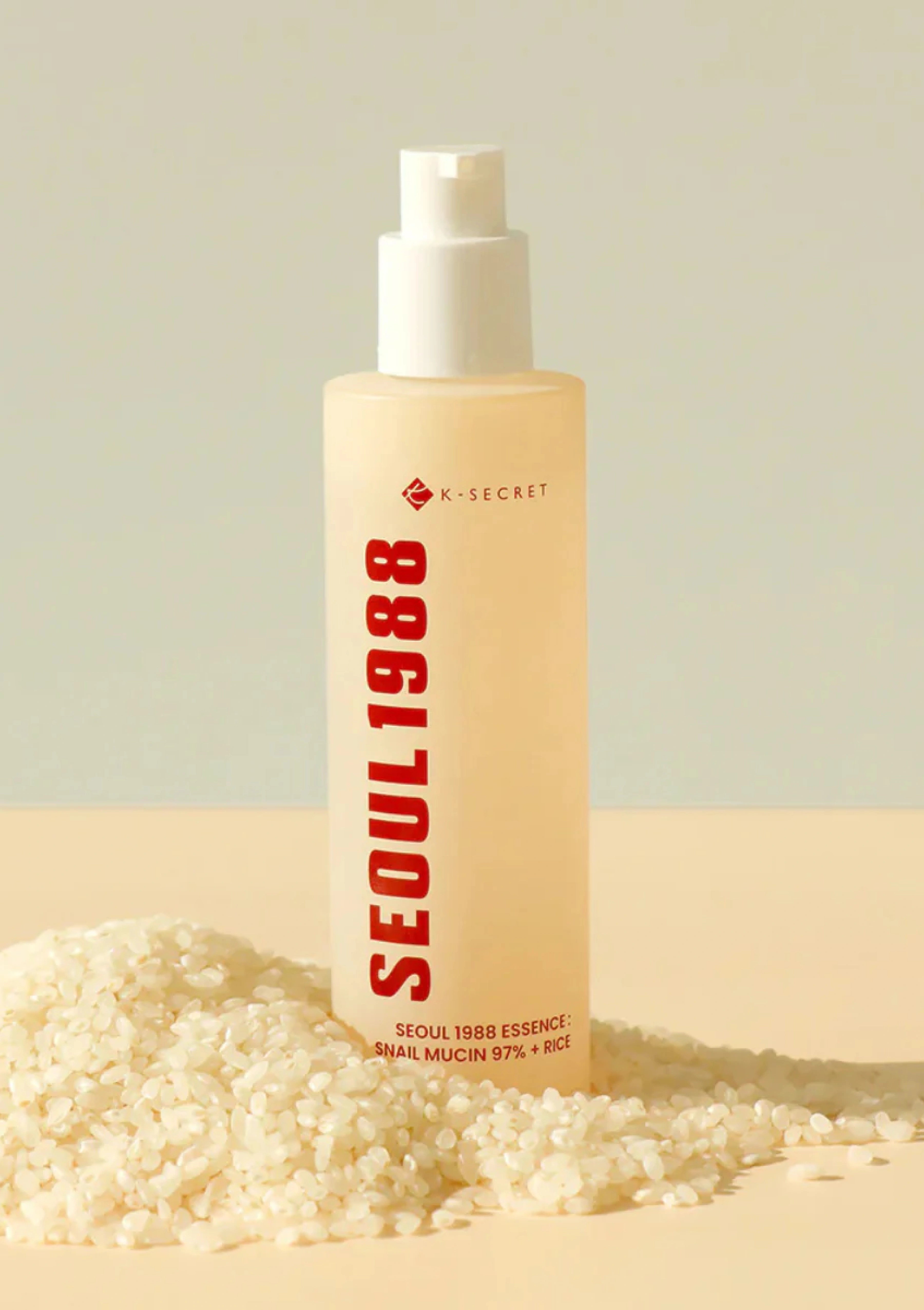 Skincare bottle labeled 'Seoul 1988' on a neutral background with rice grains.